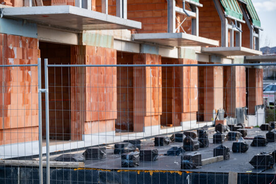 Blurred construction site through wire fence. Abstract view of development in progress.