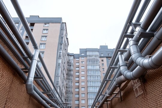Industrial Pipes on Urban Building Exterior at Modern Apartment Complex