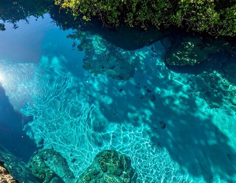 Aerial view of a pristine tropical lagoon with visible rocky bottom