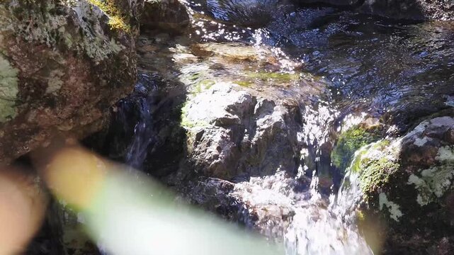 山岳地帯の清流。岩場を流れる川。水飛沫。泡立ち。苔。川音。避暑。静寂。自然風景。