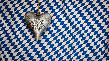 Obraz premium Metal heart hangs on blue and white checkered fabric in a traditional setting during an event