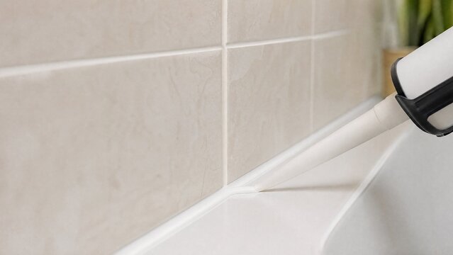 caulk. White caulk neatly filling tile gaps to create clean lines in a bathroom setting. real-estate listings, architecture portfolios, designed for interior renovation comparisons for interiors.