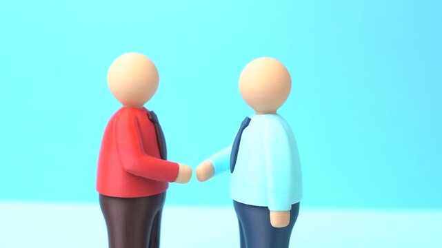 Two people shake hands to signify an agreement. To reach agreement, consensus. Business partnership, cooperation, and trust-building during negotiations or contract signing.