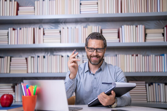 Teacher in classroom. school tutor with book in classroom. Man in class. teachers day. man tutor preparing for school exam. tutor making notes at lesson. teaching school subject. Higher education