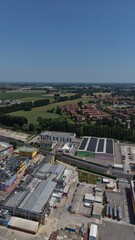 Fototapeta premium Industrial Landscape: An aerial view showcases a sprawling industrial park nestled within a rural landscape, under a clear blue sky, highlighting the intersection of industry and nature.