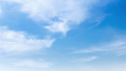 Fototapeta premium Soft clouds drift across a vast, clear blue sky
