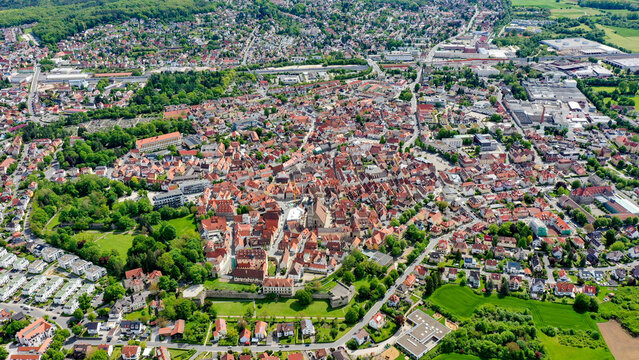 Aerial view of the historic old town with traditional red-roofed buildings, lush green parks, and residential neighborhoods under a clear sky in Forchheim, Bavaria, Germany.