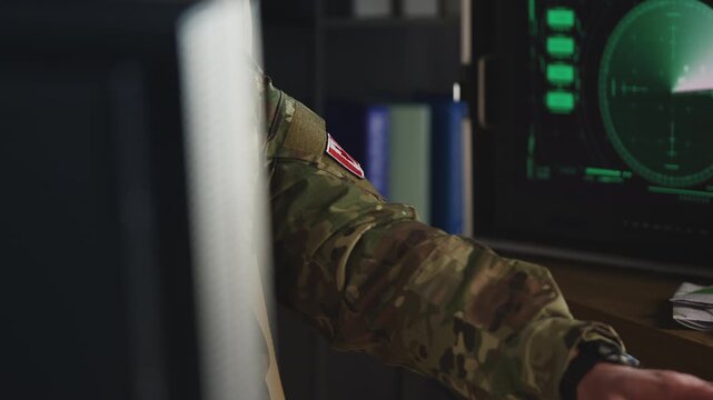 Canadian army officer working with surveillance systems on computer in office