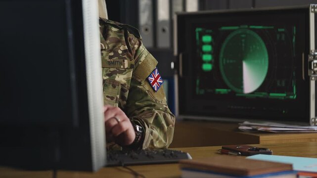U.K. military officer monitoring radar surveillance systems on computer