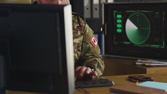 Senior Canadian air defense officer monitoring radar and updating security data
