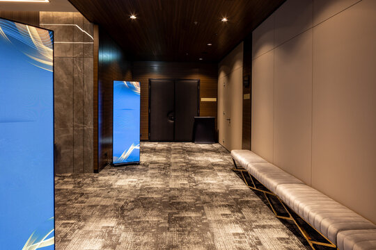 Modern hotel corridor with digital signage screens and long bench