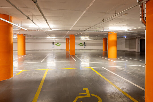 Empty underground parking garage with electric vehicle charging stations and disabled spot