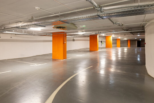 Clean underground parking garage with orange pillars and ventilation system