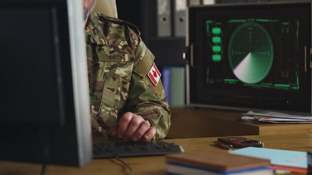 Middle-aged Canadian military officer assessing threats in command center