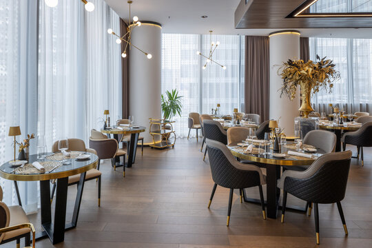 Modern luxury restaurant interior with elegant tables and large windows