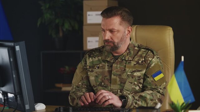 Ukrainian army officer typing on computer, planning special operations