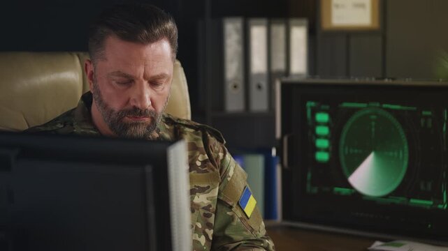Ukrainian intelligence officer monitoring air threats and typing on computer