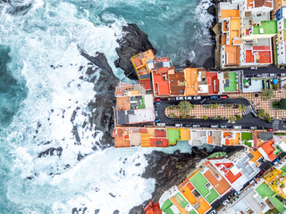 Aerial view photo from above wild waves in the Atlantic Ocean with colorful houses on Tenerife island in Puerto de la Cruz, Spain © Markus Mainka