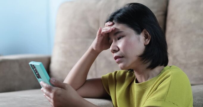 Stressed woman looking smartphone, pulling her hair, financial problems, bad news, debt daily life, social media stress, emotional breakdown, anxiety, frustration, mental pressure, intense expression