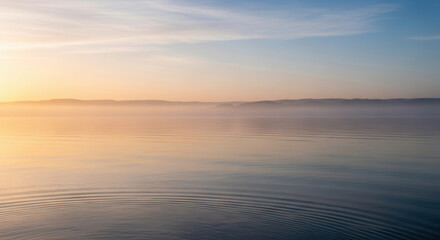Obraz premium Sunset over calm ocean waves with golden sky reflection