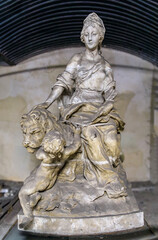 Fototapeta premium Ancient stone sculpture of a seated female figure with cherub and lion inside historic defensive structure at Ponts Couverts in Strasbourg, France