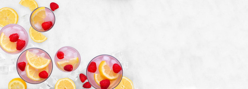 Sweet summer pink lemonade corner border. Top view on a white marble banner background with copy space.