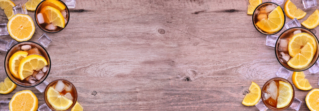 Sweet summer iced tea double border. Overhead view on a wood banner background with copy space.