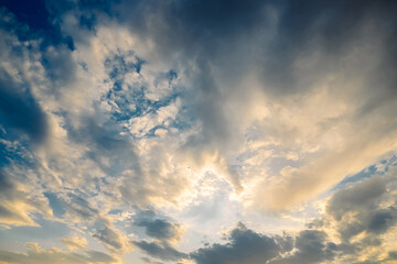 Fototapeta premium Clouds fill sky as sun sets over ocean in coastal area. Colors change as light fades day comes to an end, marking transition to night. Clouds move across sky during sunset near ocean