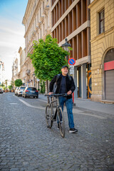 Fototapeta premium Confident bald man with his bicycle in the city