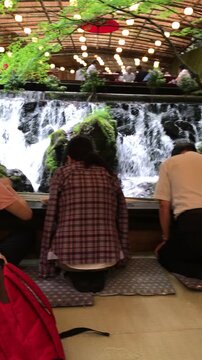 People enjoying a serene waterfall dining experience with ambient lighting