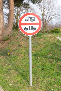 No camping and caravan parking road sign. Circular red and white restrictive road sign prohibiting camper vans, motorhomes, and travel trailers parking, installed on ametal pole