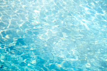 Obraz premium Bright, clear blue water in a swimming pool creates mesmerizing patterns and reflections under sunlight. The vibrant aqua hues and gentle ripples evoke a serene, refreshing feeling.