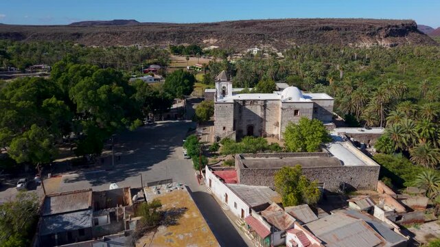 See aerial views of Mission Church in San Ignacio, Baja California, highlighting the oasis town and nearby structures in clear detail.