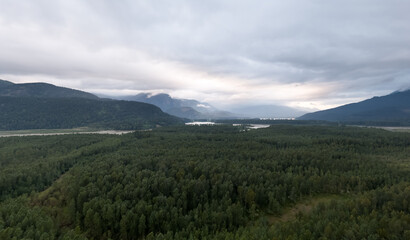 Fototapeta premium Misty Mountain Valley Over Dense Forest and River in Fraser Valley, British Columbia, Canada
