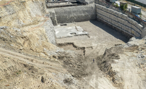 Aerial view of a large construction site excavation with deep retaining walls and a concrete foundation base in Sariyer, Istanbul, Turkiye.