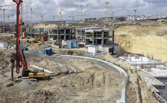 Aerial view of a large construction site with multiple tower cranes, concrete building frames, and heavy machinery in Sariyer, Istanbul, Turkiye.
