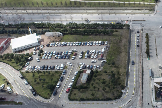 Aerial view of a parking lot with rows of vehicles and a small white building surrounded by trees Sariyer, Istanbul, Turkiye.