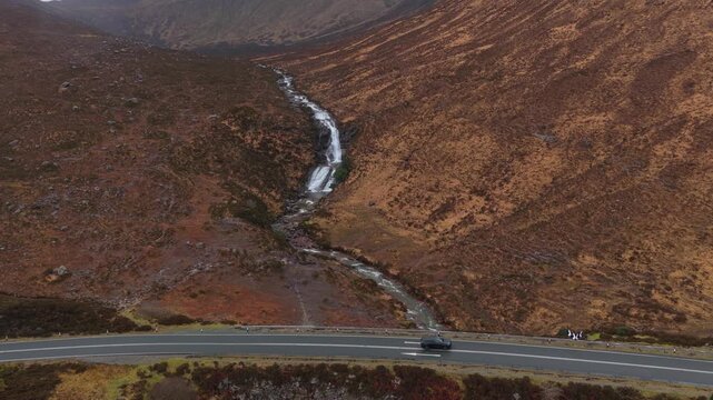Scenic eas a' bhradain waterfall flowing through scottish highlands valley