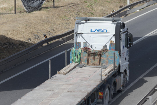 White laso truck moving on highway with flatbed trailer
