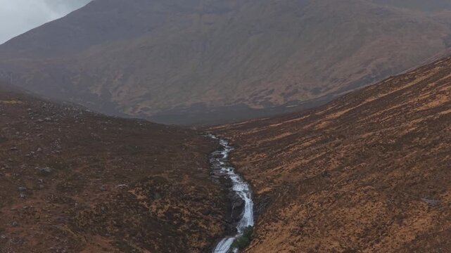 Eas a' bhradain waterfall flowing through scottish highlands valley