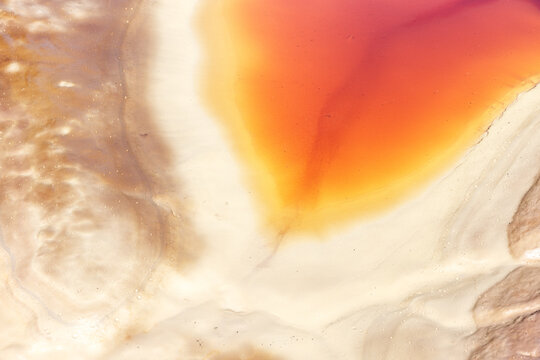 Aerial view of the vibrant red and orange acidic waters of the Rio Tinto river flowing through the mineral-rich landscape of Minas de Riotinto, Andalusia, Spain.