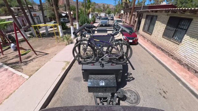 Teardrop camper trailer tows through the narrow streets of Mulege in Baja California Sur while capturing local scenery and houses.