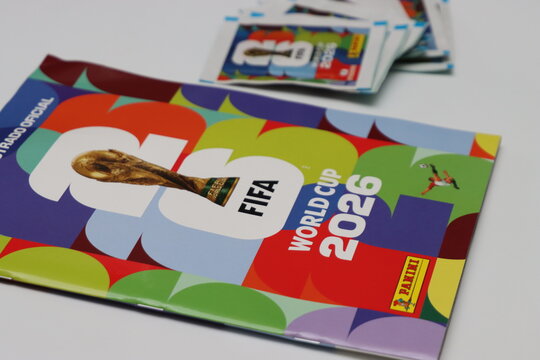 A collection of Panini sticker packets and an album for the FIFA World Cup 2026 tournament, featuring the iconic trophy