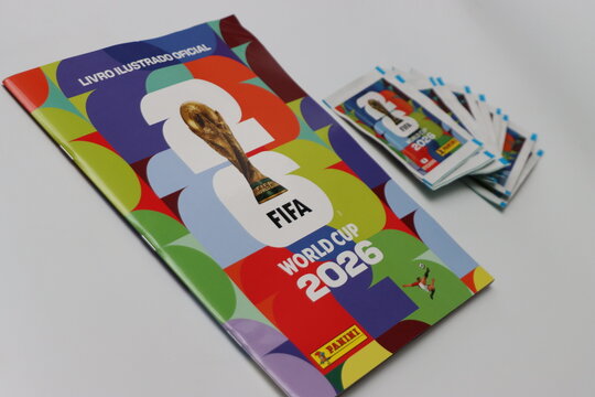 A collection of Panini sticker packets and an album for the FIFA World Cup 2026 tournament, featuring the iconic trophy