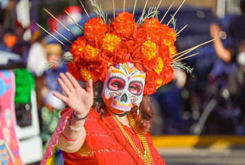 EL PASO, TEXAS – NOVEMBER 01, 2025: A festival participant wearing an elaborate orange and red...