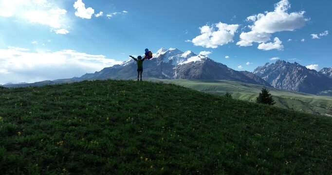 Woman with colorful balloons on sunset grassland mountain top