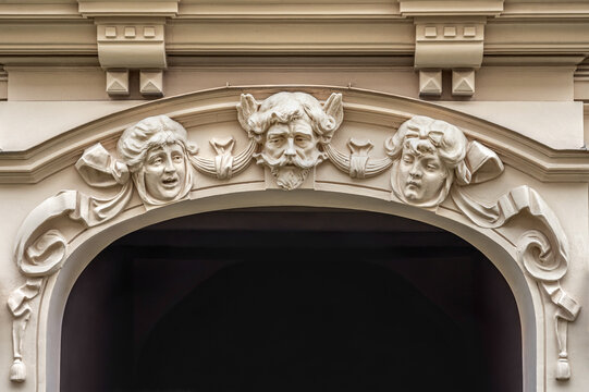 Decorative entrance arch with sculpted male and female mascarons on a classic Art Nouveau and Jugendstil facade with copy space in Riga, Latvia