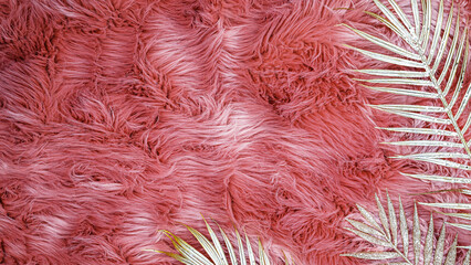 Fototapeta premium Soft pink texture with tropical leaves on a pink background during indoor daylight