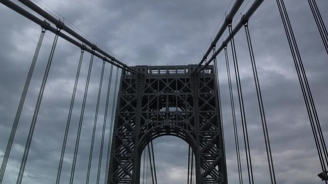 point of view of car driving over george washington bridge between fort lee new jersey and manhattan york heights (sunset night time cloudy suspension bridge)
