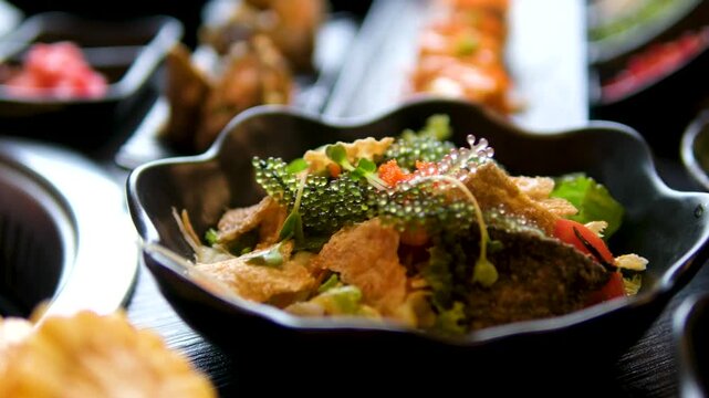 korean buffet seafood seaweed salad in black plates with dipping sauce close up 